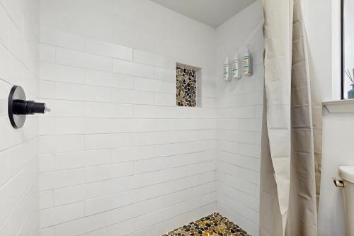 a bathroom with a shower with white tiles at Sunset Harbor Palms 1-204 in Navarre