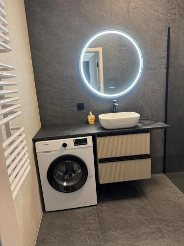 a bathroom with a washing machine and a sink at Pokoje Warszawski Świt in Warsaw
