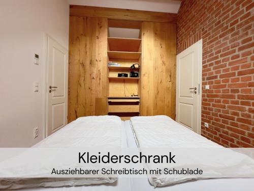 a bedroom with a bed and a brick wall at HexenburgbeiDresden 2 Zimmer Architektenwohnung mit eigener Sauna, Whirlwanne und Kamin - Nähe Sächsische Schweiz Dresden in Großharthau