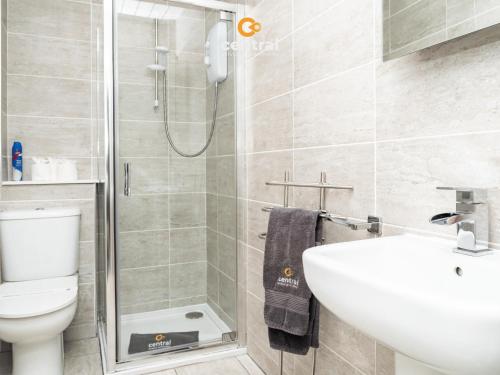 a bathroom with a shower and a sink and a toilet at Trades Lane by CENTRAL SERVICED APARTMENTS - Cosy 1 Bedroom - Walk Away From City Quay V&A - Walk to Bus and Train Station - Easy Access to City Centre - Fast Wi-Fi - Fully Equipped - Weekly & Monthly Stay Offers in Dundee