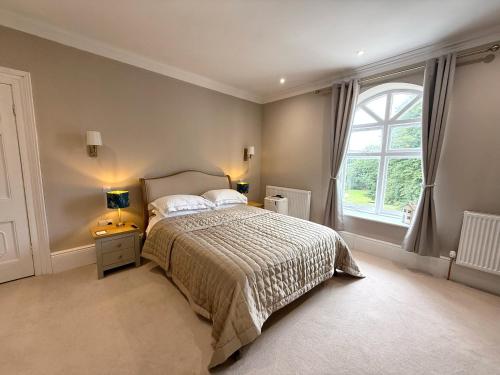 a bedroom with a bed and a large window at Moorswater Lodge in Liskeard