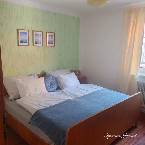 a bedroom with a large bed with a blue blanket at Himmel in Ebensee