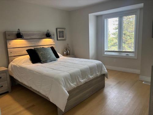 a bedroom with a large bed and a window at Main Unit Luxury South Windsor Oasis in Windsor