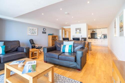 a living room with a couch and a table at Fistral Beach Garden Apartment 3 in Newquay