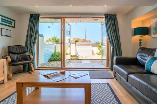 a living room with a couch and a table at Fistral Beach Garden Apartment 3 in Newquay