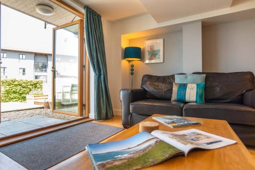a living room with a couch and a table at Fistral Beach Garden Apartment 3 in Newquay