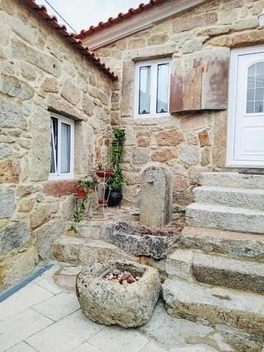 a stone building with a stone bowl in front of it at Casa do Regedor in Pinhel