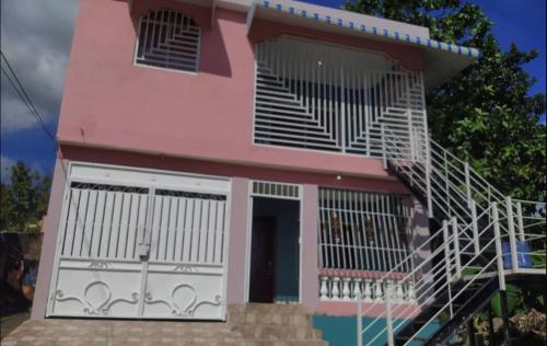 a pink house with a staircase in front of it at Don Carlos Recidencia in Camarón