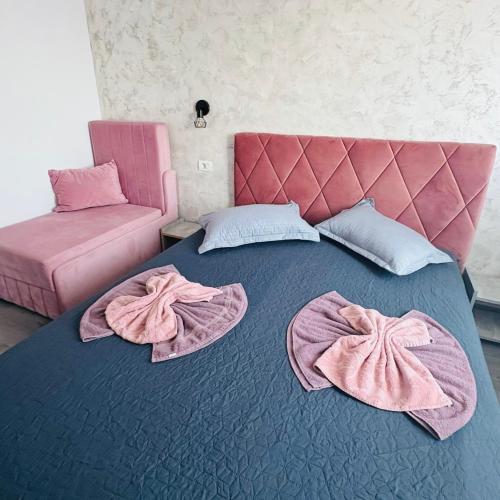 a pink bed with pink robes on top of it at Ama boutique in Constanţa