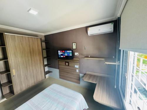a small room with a bed and a tv at Casa espaçosa - 3 quartos - Caçari in Boa Vista