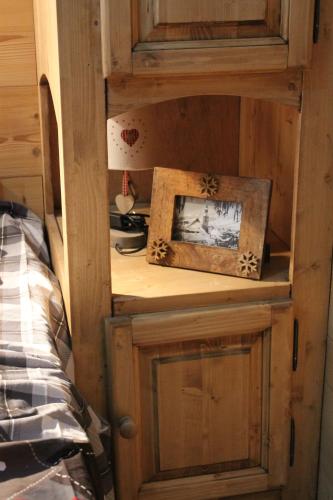 a wooden cabinet with a picture and a picture frame at Chalet des pistes in Megève