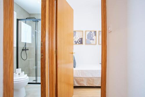 a bathroom with a toilet and a bed in a room at Alcam Terrassa in Terrassa