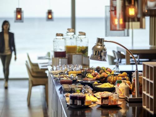 uma linha de buffet com muitos alimentos diferentes nele em Novotel Thalassa Le Touquet em Le Touquet-Paris-Plage