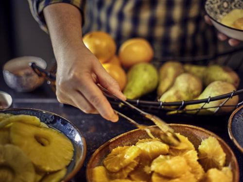 uma pessoa cortando frutas com garfo e faca em Novotel Thalassa Le Touquet em Le Touquet-Paris-Plage