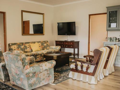 a living room with a couch and a tv at Ontevreden Farm in Montagu