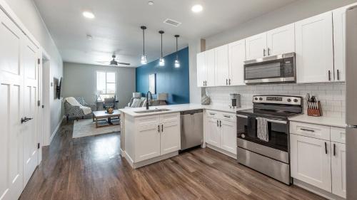 a kitchen with white cabinets and a stove top oven at Landing Apartments at Ballpark Village - Goodyear in Goodyear