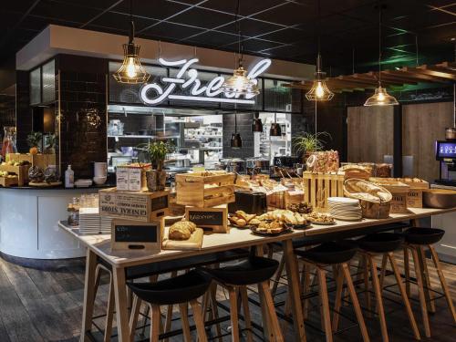Una panadería con una mesa grande con comida encima. en Novotel Valence Sud, en Valence