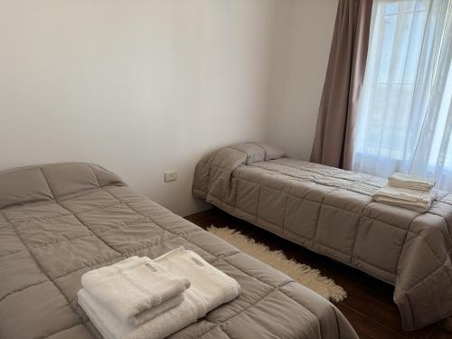 una camera con due letti e asciugamani sul pavimento di Casa Quinta Suipacha a Suipacha