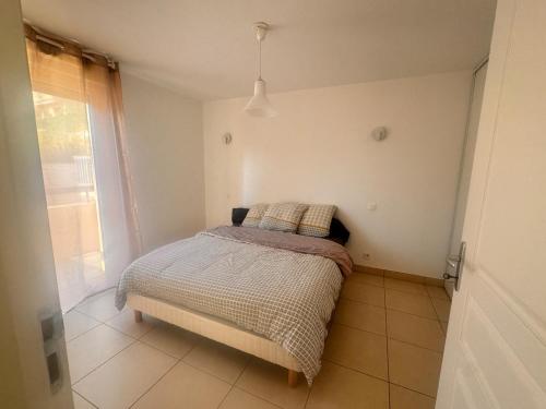 een klein bed in een kamer met een raam bij Appart 2 Chambres Charley super emplacement et parking in Calvi