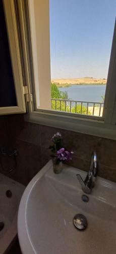 a bathroom sink with a window with a view of the water at Golden Sun House I in Abu Simbel
