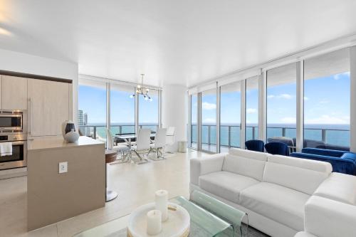 a living room with a white couch and a kitchen at Dreamy Beachside Living - Direct Oceanview 2BR 2BA for the Perfect Escape in Hollywood