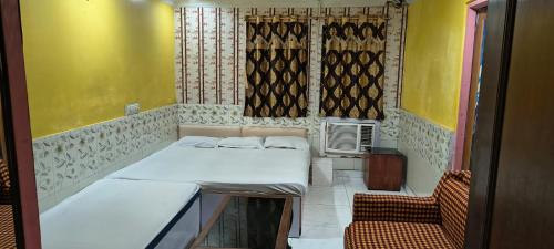 une petite chambre avec deux lits et une chaise dans l'établissement Gulshan Cottage, à Mussoorie