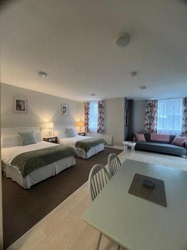 a hotel room with two beds and a table at Birch Lane Guesthouse in Wexford