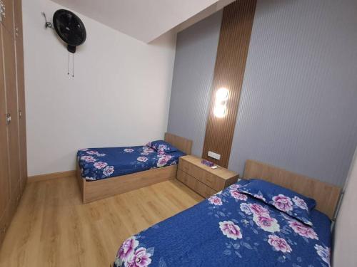 a small bedroom with two beds and a fan at Tiara Homestay Bandar Baru Kuala Lipis in Kuala Lipis