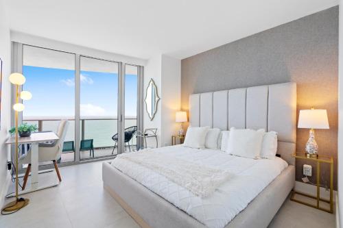 a bedroom with a large white bed with a view of the ocean at Dreamy Beachside Living - Direct Oceanview 2BR 2BA for the Perfect Escape in Hollywood