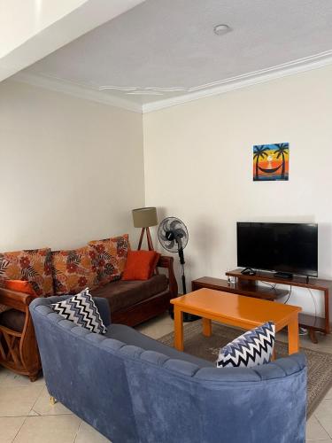 a living room with a couch and a table at Karma Homes in Buye