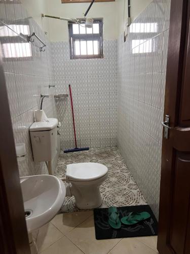 a bathroom with a toilet and a sink at Karma Homes in Buye