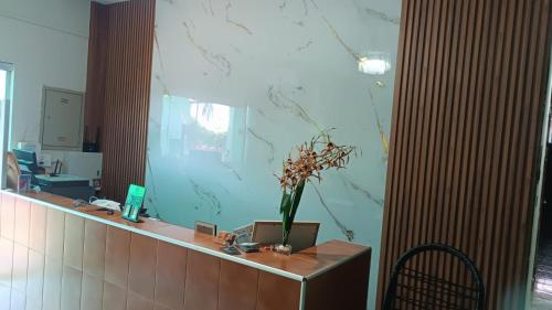 a reception counter with a vase of flowers on it at HOTEL RECANTO DOS BURITIS in Buritizal