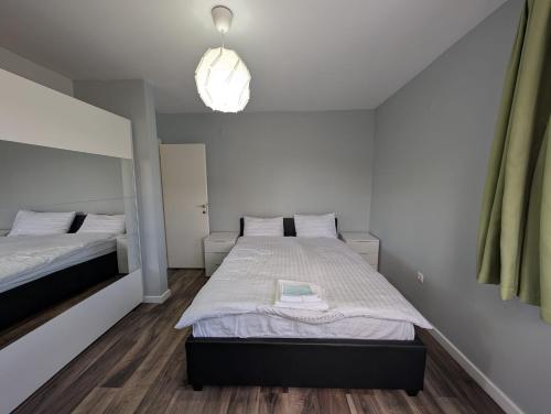 a bedroom with two beds and a pendant light at Apartament spatios, mobilat si utilat complet in Floreşti