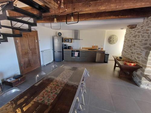 un salon avec une table et une cuisine dans l'établissement La maison de Louise, à Colombiès