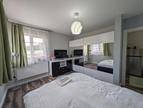 a bedroom with a bed and a desk and a television at Apartament spatios, mobilat si utilat complet in Floreşti