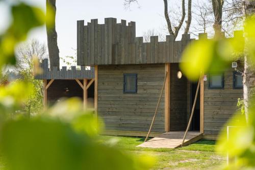 a small wooden house with a fence on top at Kasteel Uylenburght in Rheeze