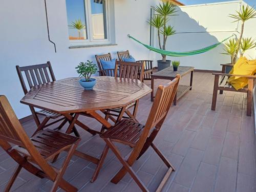a wooden table and chairs on a patio at T2 Moliceiros Torreira vista Ria in Torreira