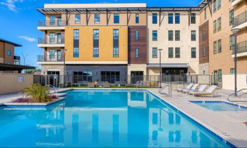 a swimming pool in front of a building at Landing Apartments at Ballpark Village - Goodyear in Goodyear