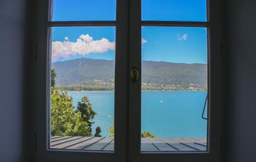 - une fenêtre avec vue sur une étendue d'eau dans l'établissement Le Palace De Menthon, à Menthon-Saint-Bernard