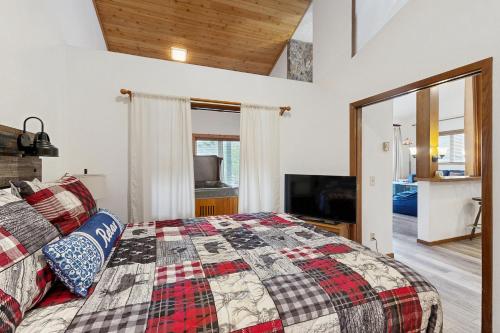 a bedroom with a king sized bed and a television at Mountainside 049 in Granby