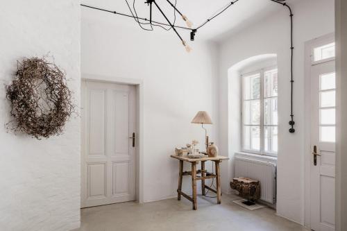 a room with white walls and a door and a table at Wabi Sabi Loft im Wienerwald in Laaben