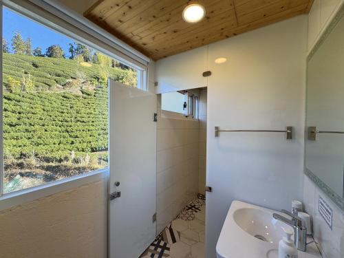 Un baño con lavabo y ventana. en Alishan B&B YunMinGi, en Fenchihu