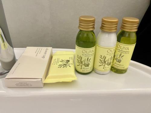 three bottles of vinegar and a book on a shelf at Dimora Soprana - Affittacamere confortevole in Genova