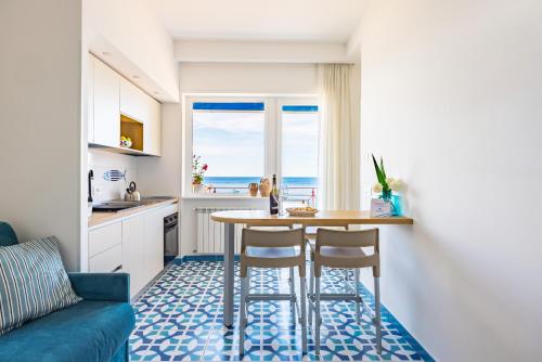 Una cocina y una sala de estar con mesa y sillas. en Blumare Amalfi Coast, en Maiori