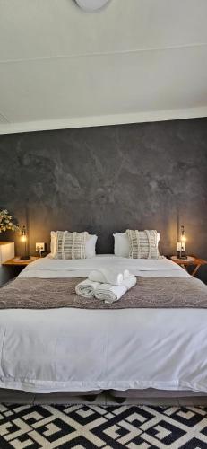 a bedroom with a large bed with white sheets and pillows at Bo Kamer Guesthouse in Ermelo