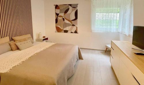 a bedroom with a bed and a flat screen tv at PULLY LAUSANNE sunny apartment on lakeside street and direct bus to Lausanne train station in Pully
