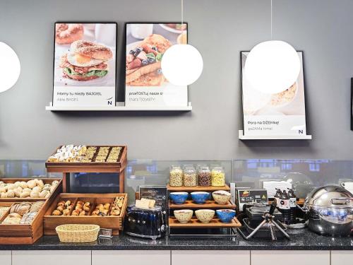 Un mostrador de panadería con pasteles y carteles en la pared. en Novotel Wrocław City, en Wroclaw