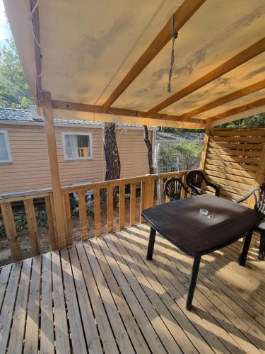 een patio met een tafel en een bank op een terras bij Mobile-Home 6 places Nans les pins in Nans-les-Pins