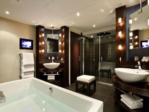 Un baño con bañera, lavabo y ducha. en Sofitel Marseille Vieux-Port, en Marsella