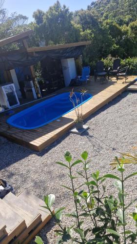 a backyard with a swimming pool and a wooden deck at Cabanas de Marina in Imbituba